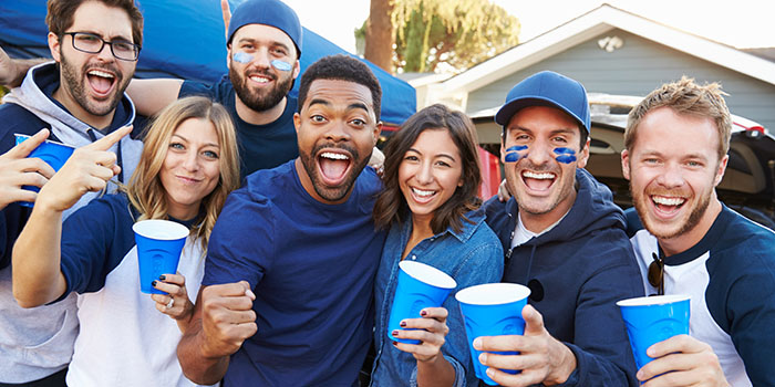 Group Of Sports Fans Tailgating In Stadium Car Park