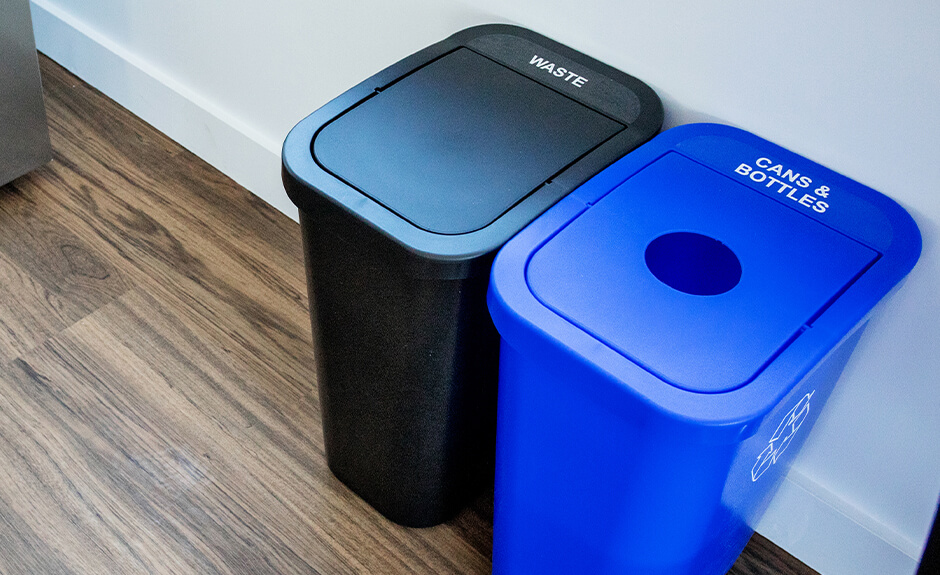 Two Busch Systems Billi Box containers in black for waste and blue for cans and bottles