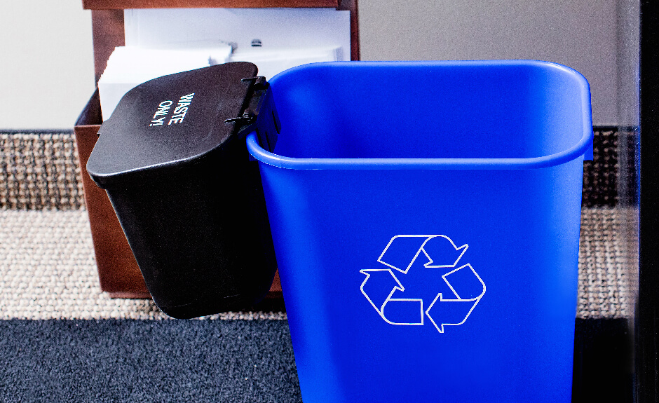 Busch Systems black hanging waste basket attached to blue recycling container with mobius loop graphic