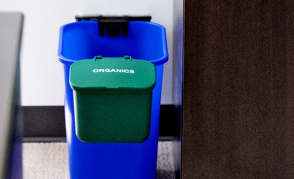 Busch Systems green organics hanging waste basket attached to blue recycling container