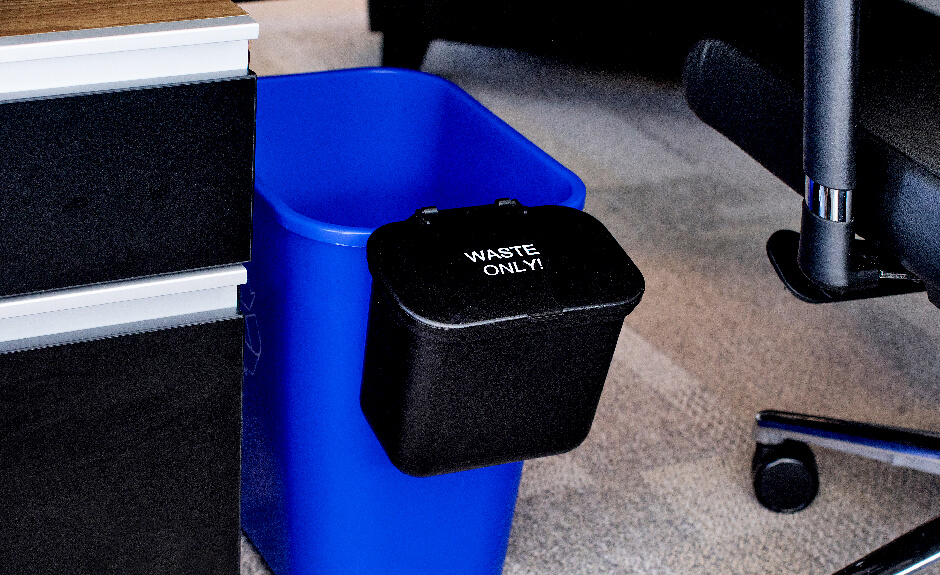 Busch Systems black hanging waste basket attached to blue recycling container