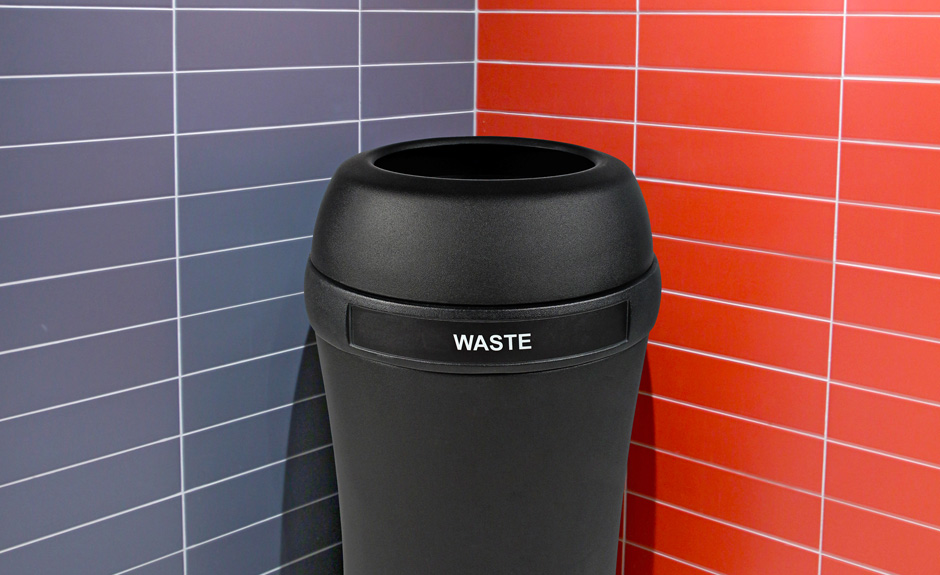 Busch Systems Infinite waste container in black with full open lid in washroom