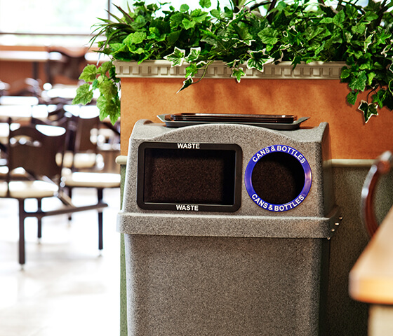 Busch Systems grey Wave container with double opening for waste and recyclables at a restaurant
