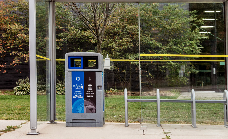 Busch Systems Expression double stream container with an Anywhere Bracket attached at a bus shelter