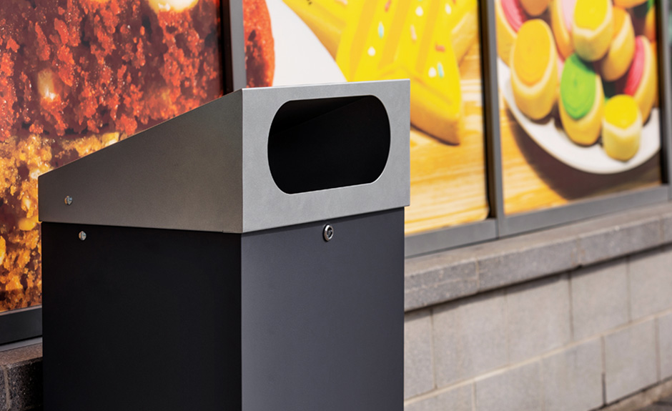 Busch systems reflection outdoor waste and recycling container shown in a shopping plaza