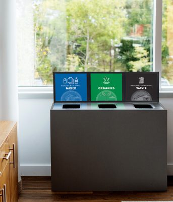 indoor three-stream recycling station for mixed recyclables, organics, and waste placed by a window in a modern office