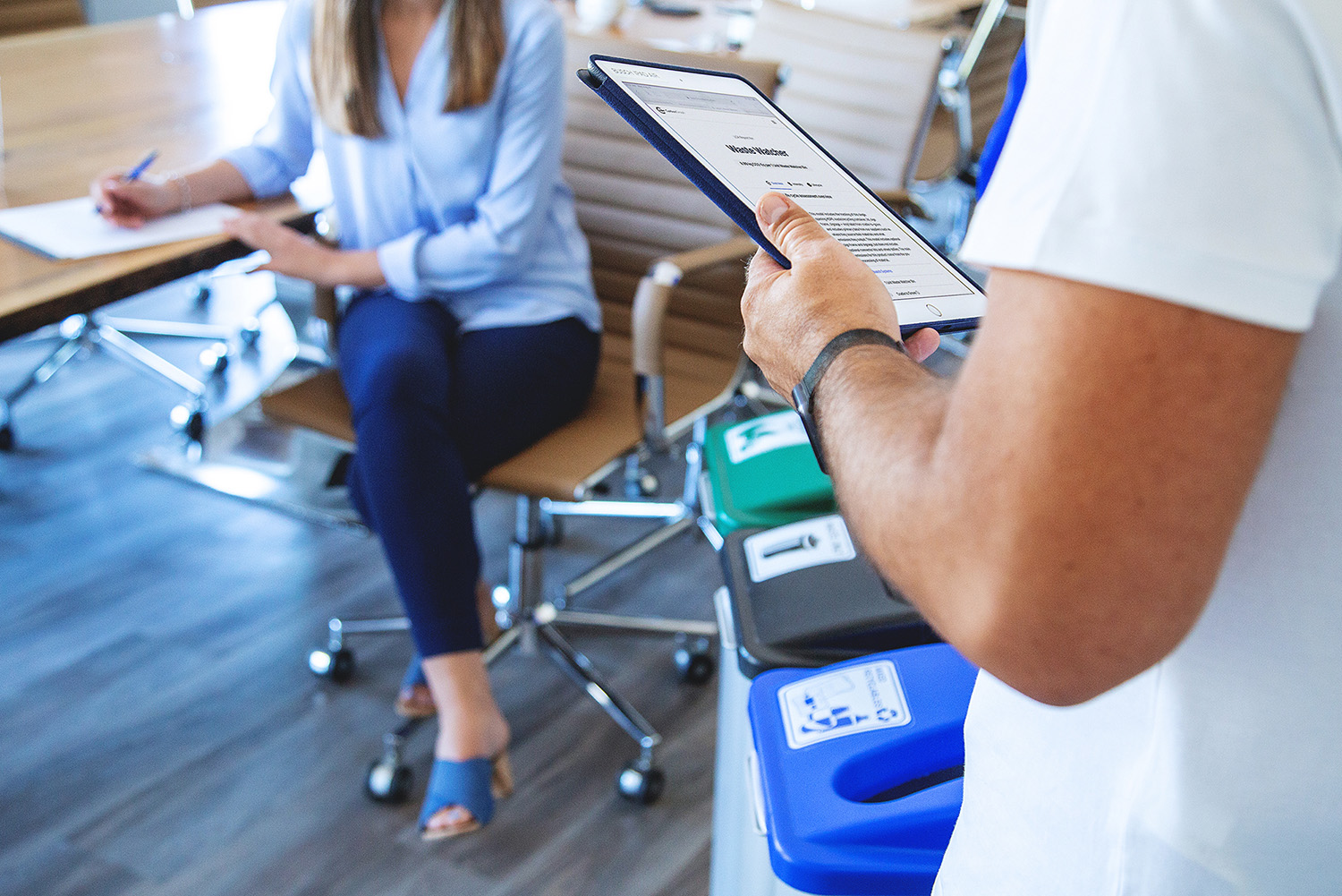 two people talking in an office next to waste sorter bins