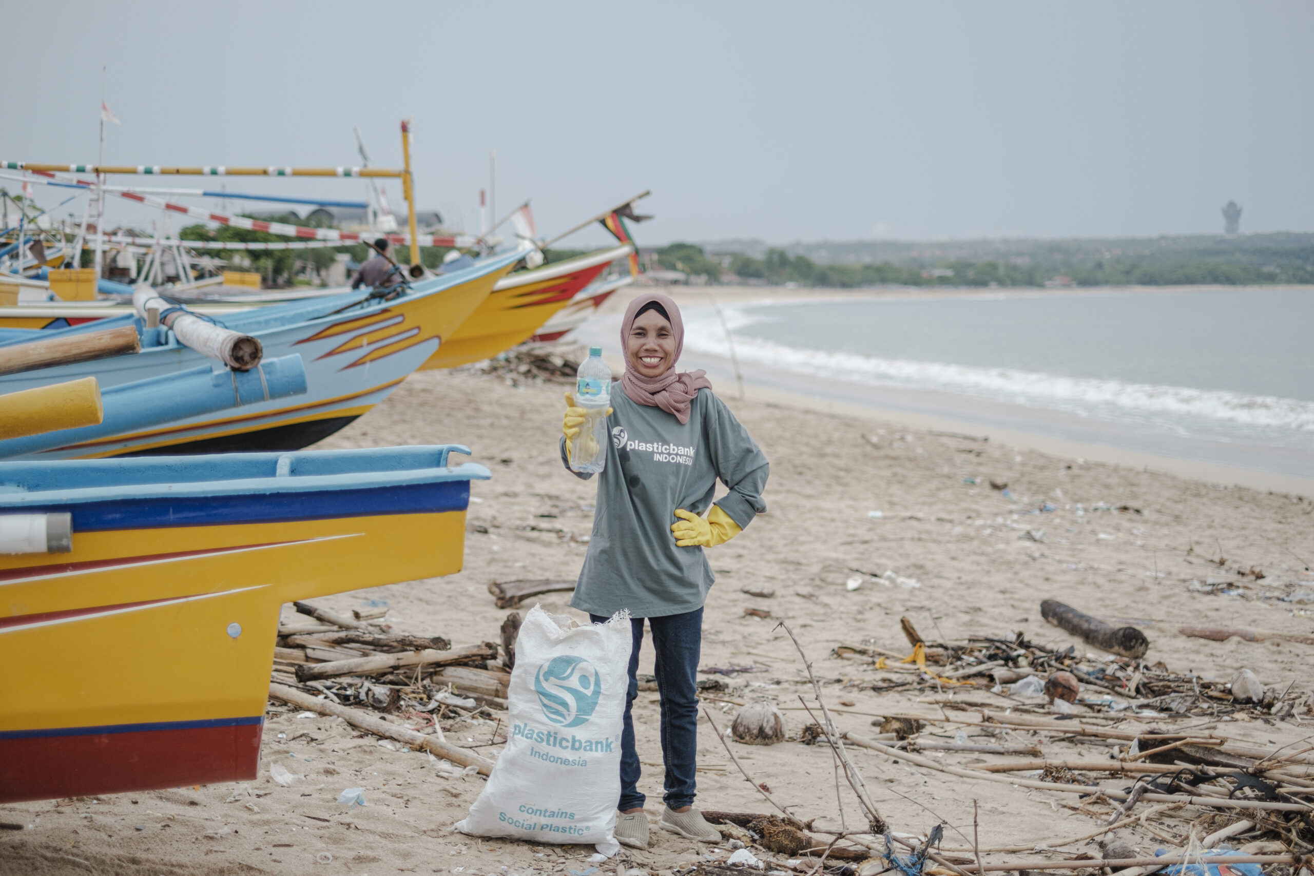 woman picking up plastic waste from the beach