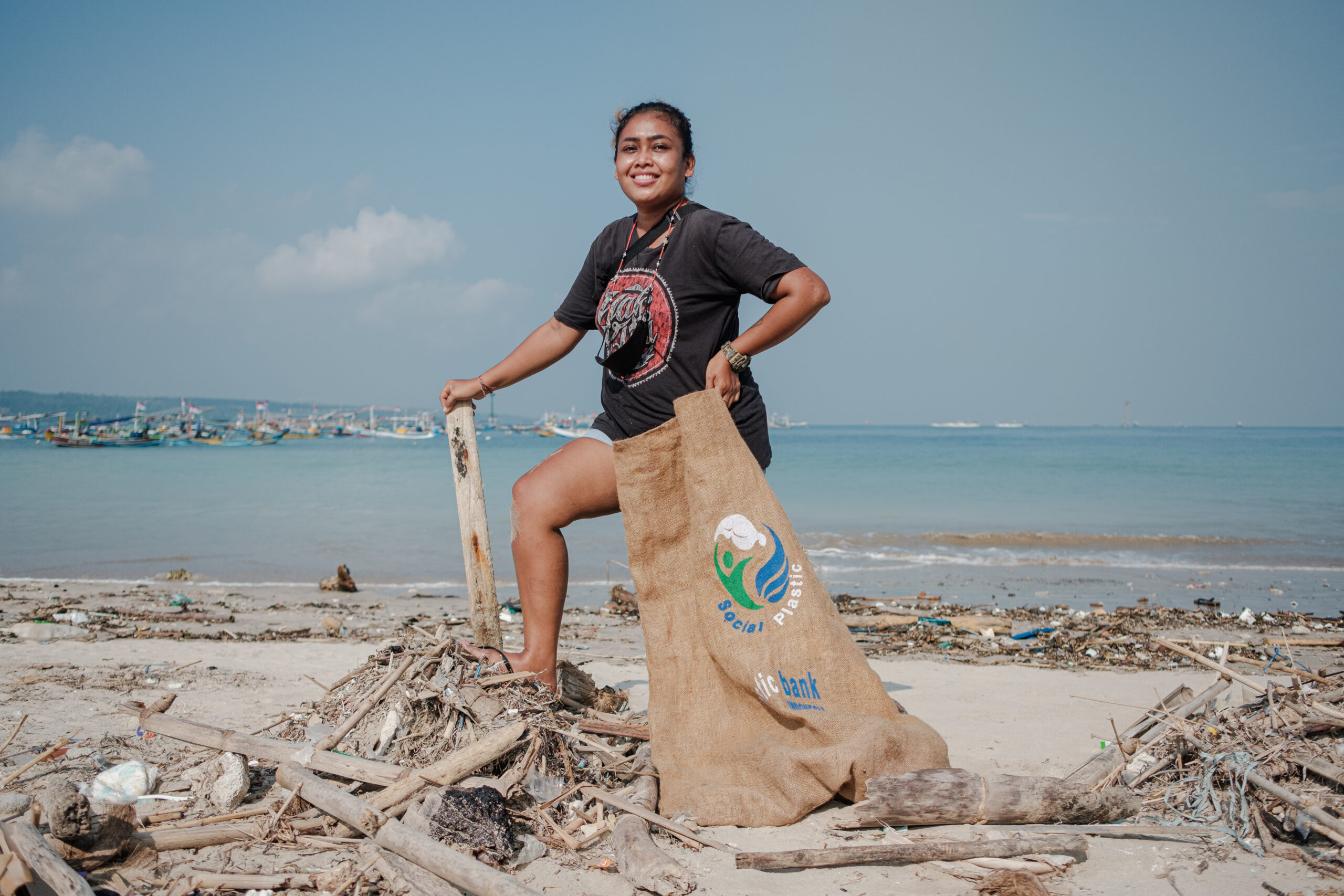 woman picking up waste from the beach