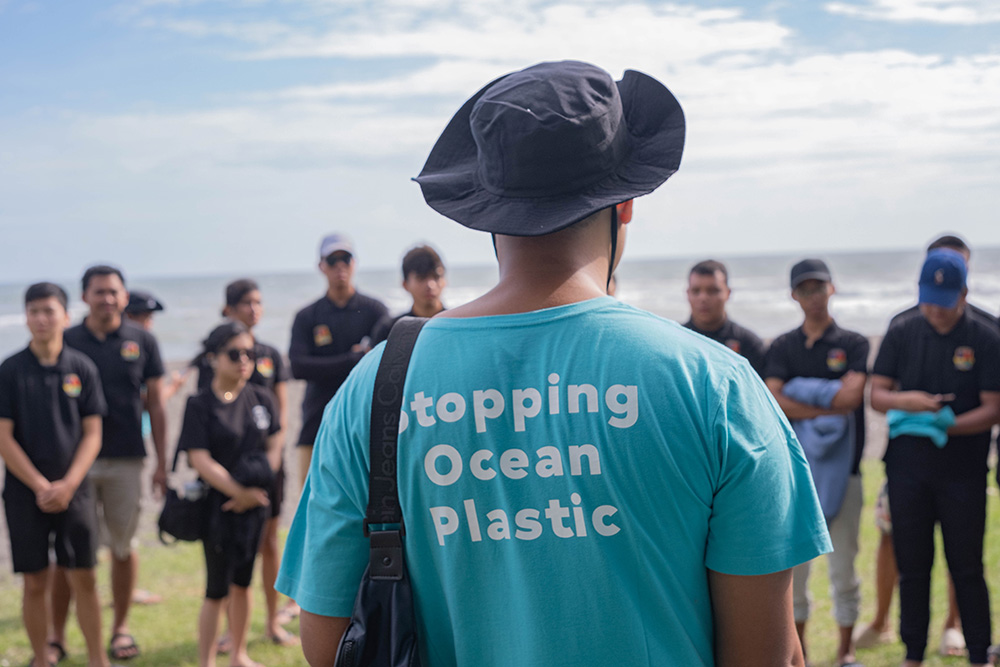 a group of people talking about stopping ocean plastic