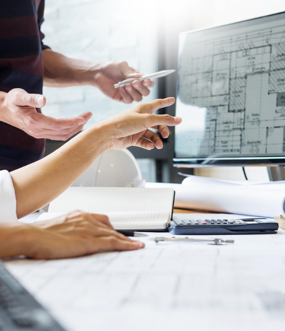 architects working on a building project design pointing at a computer screen in a modern office