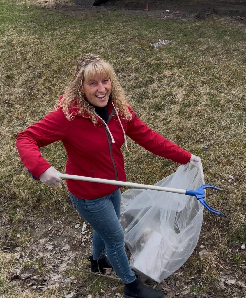 woman wearing red sweater picking up trash