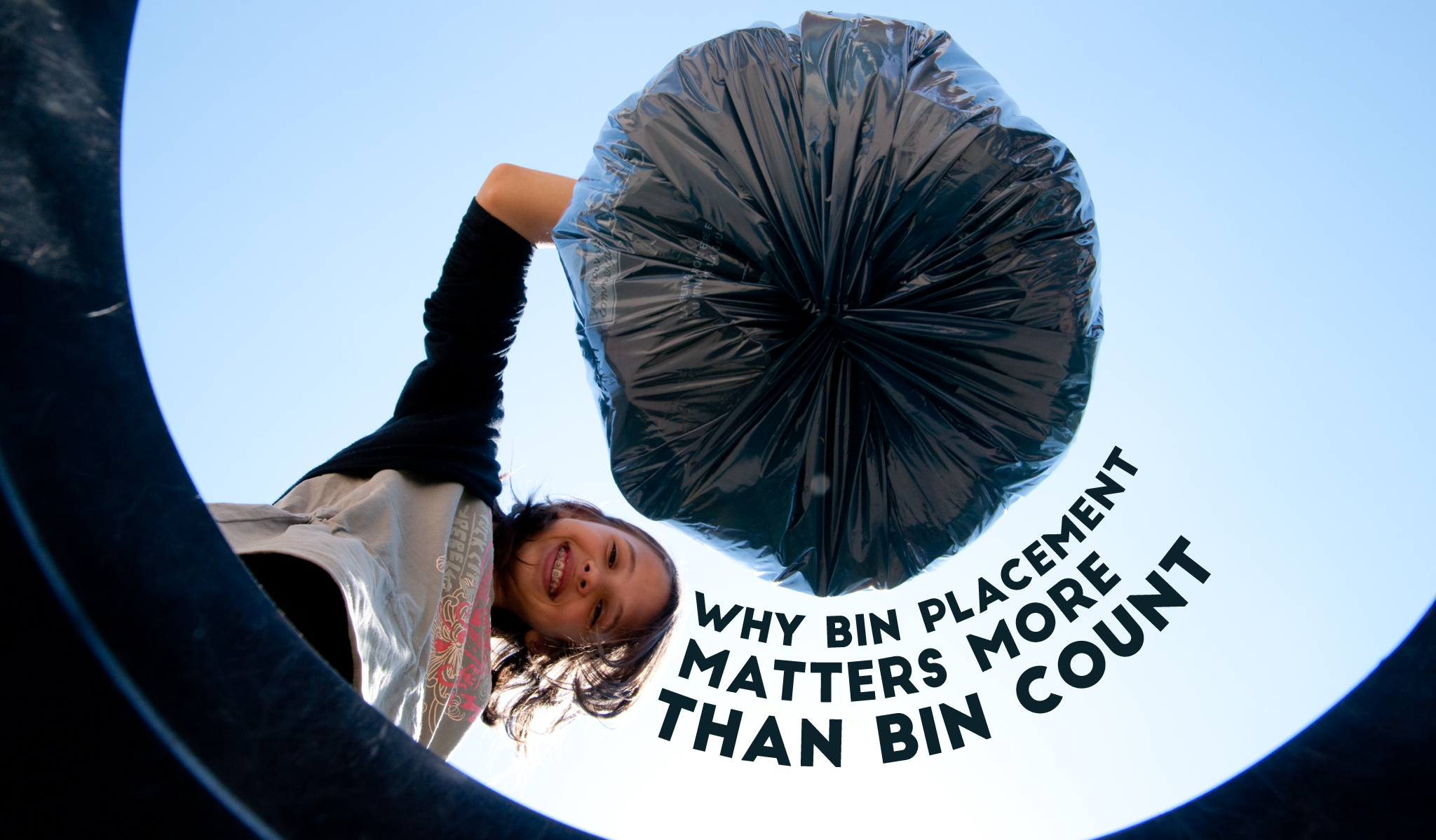 someone putting a trash bag into a bin