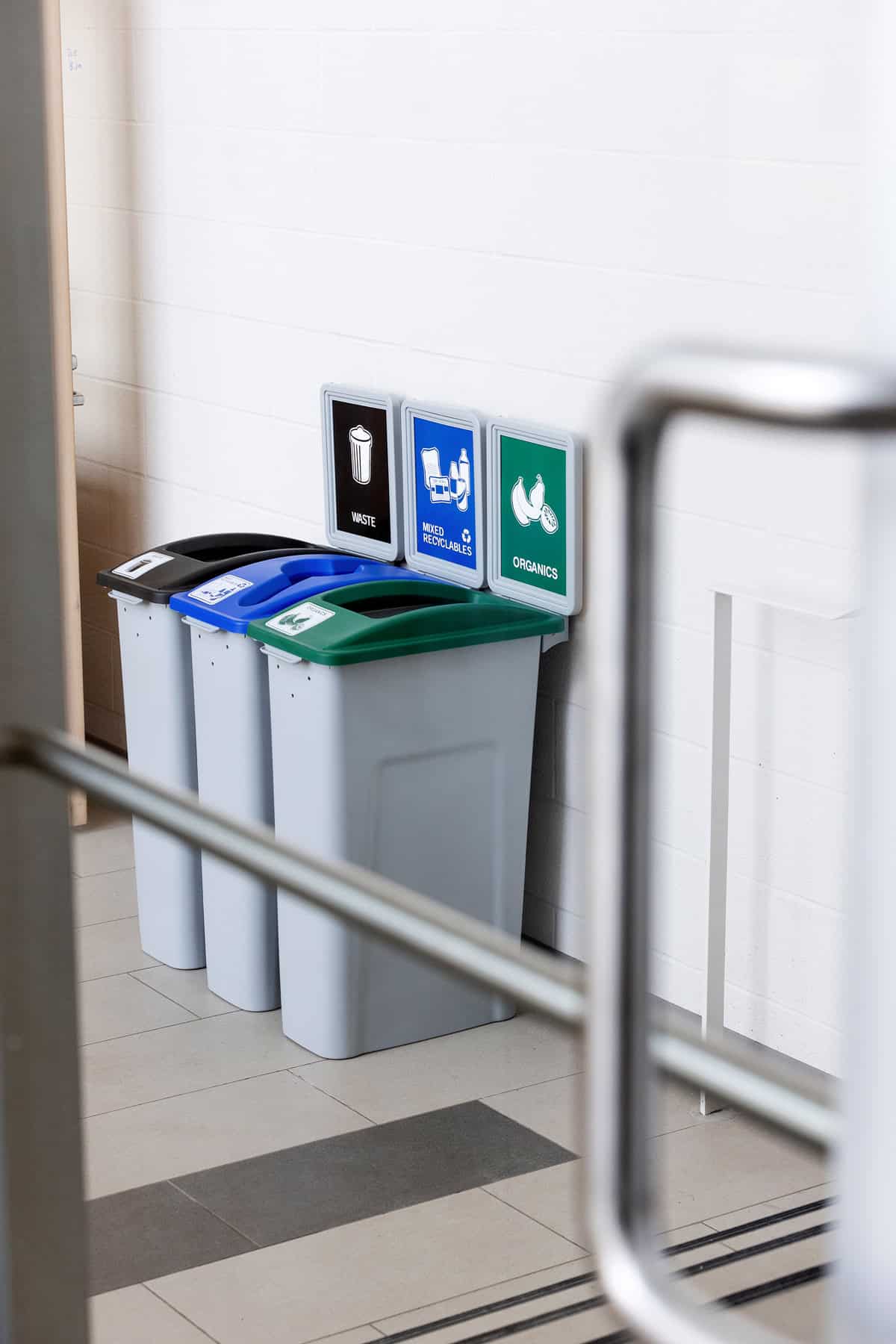 waste recycling and organics bins visible through an open door